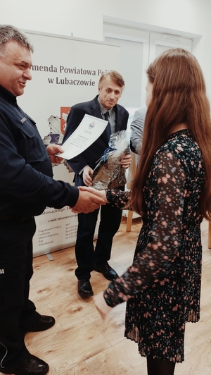 Na zdjęciu Komendant Powiatowy Policji w Lubaczowie wraz z Burmistrzem Miasta Lubaczowa wręczają nagrodę laureatce konkursu.