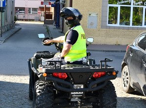 Na zdjęciu umundurowany policjant w kamizelce odblaskowej na quadzie.