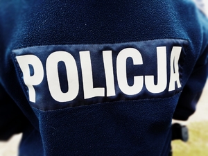 Na zdjęciu policjant w umundurowaniu służbowym. Na polarze w kolorze granatowym napis policja.