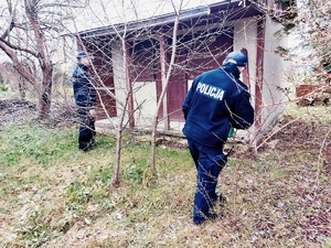 Na zdjęciu policjanci w umundurowaniu służbowym sprawdzają pustostan.