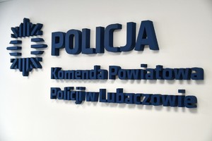 zdjęcie przedstawia napis na ścianie z niebieskich liter pn Komenda Powiatowa Policji w Lubaczowie.