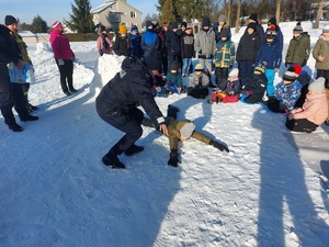 Na zdjęciu znajduje się policjantka która wraz z uczniem lezącym na ziemii pokazują jak się zachować gdy załamie się pod nami lód.