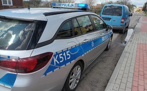 Na zdjęciu oznakowany radiowóz Policji i niebieski samochód marki Volkswagen.