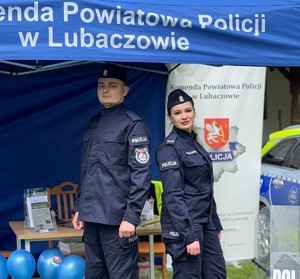 Na zdjęciu policjant i policjantka w umundurowaniu służbowym.