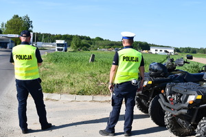 Na zdjęciu dwóch umundurowanych policjantów w kamizelce odblaskowej stoją przy quadach.