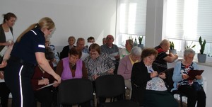 Na zdjęciu policjantka w umundurowaniu służbowym i uczestnicy debaty.