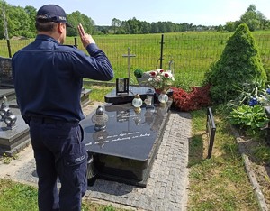 Na zdjęciu umundurowany policjant przy grobie oddający honor.