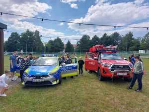 Na zdjęciu oznakowany pojazd policji oraz OSP, a także uczestnicy spotkania.