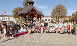 Zdjęcie grupowe ma tle studni przedstawiające wszystkich uczestników wydarzenia.