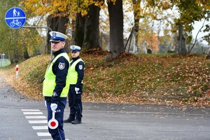 Dwóch policjantów z ruchu drogowego na drodze.