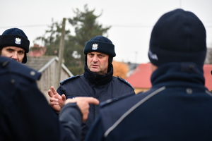 Policjant w umundurowaniu służbowym, przeprowadzający instruktaż.