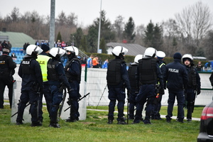 Kilku policjantów umundurowanych w zestawie przeciwuderzeniowym.