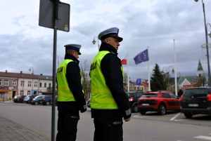 Policjanci z ruchu drogowego obserwują przejście dla pieszych.