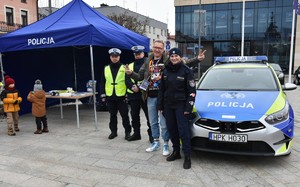 Policjanci i mężczyzna przed radiowozem.