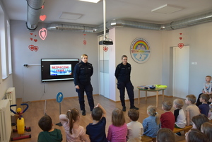 Przedszkolaki i policjantki przeprowadzające prelekcję.