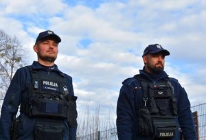 Dwóch umundurowanych policjantów w tle niebo.