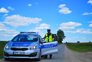 Policjant przy radiowozie.