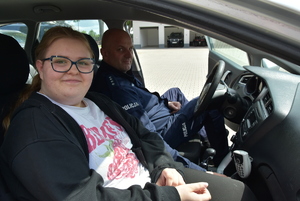 Dziewczynka i policjant w radiowozie.