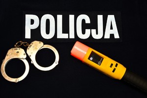 Napis policja, kajdanki i alkomat.