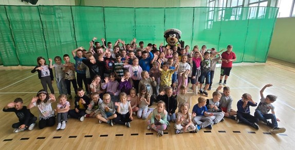 Grupa dzieci w hali sportowej.