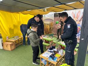 Policjanci  w umundurowaniu służbowym i uczestnicy kiermaszu.