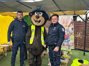 policjanci w mundurach i  miś policyjny.