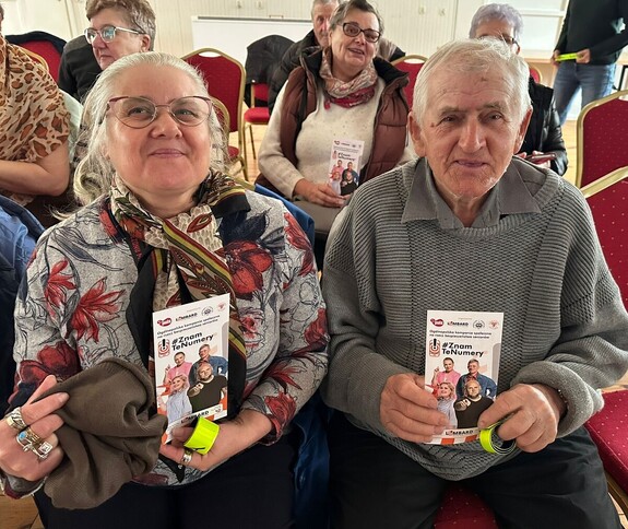 Seniorzy z ulotkami.