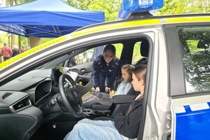 Policjantki, dzieci, stoisko profilaktyczne, radiowóz, zabawa.