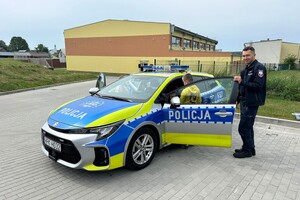 Policjantka, policjant, radiowóz i dzieci.