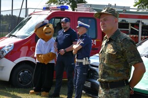 Mundurowi wraz z dziećmi i młodzieżą oraz pojazdy służbowe i wyposażenie do służby.