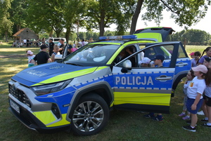 Mundurowi wraz z dziećmi i młodzieżą oraz pojazdy służbowe i wyposażenie do służby.