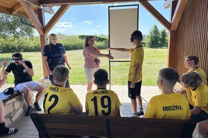 Zdjęcia przedstawiają spotkania profilaktyczne prowadzone przez funkcjonariuszkę policji oraz przedstawicielkę sanepidu w Lubaczowie. Spotkania z uczestnikami obozów piłkarskich w Cieszanowie oraz w Dachnowie.